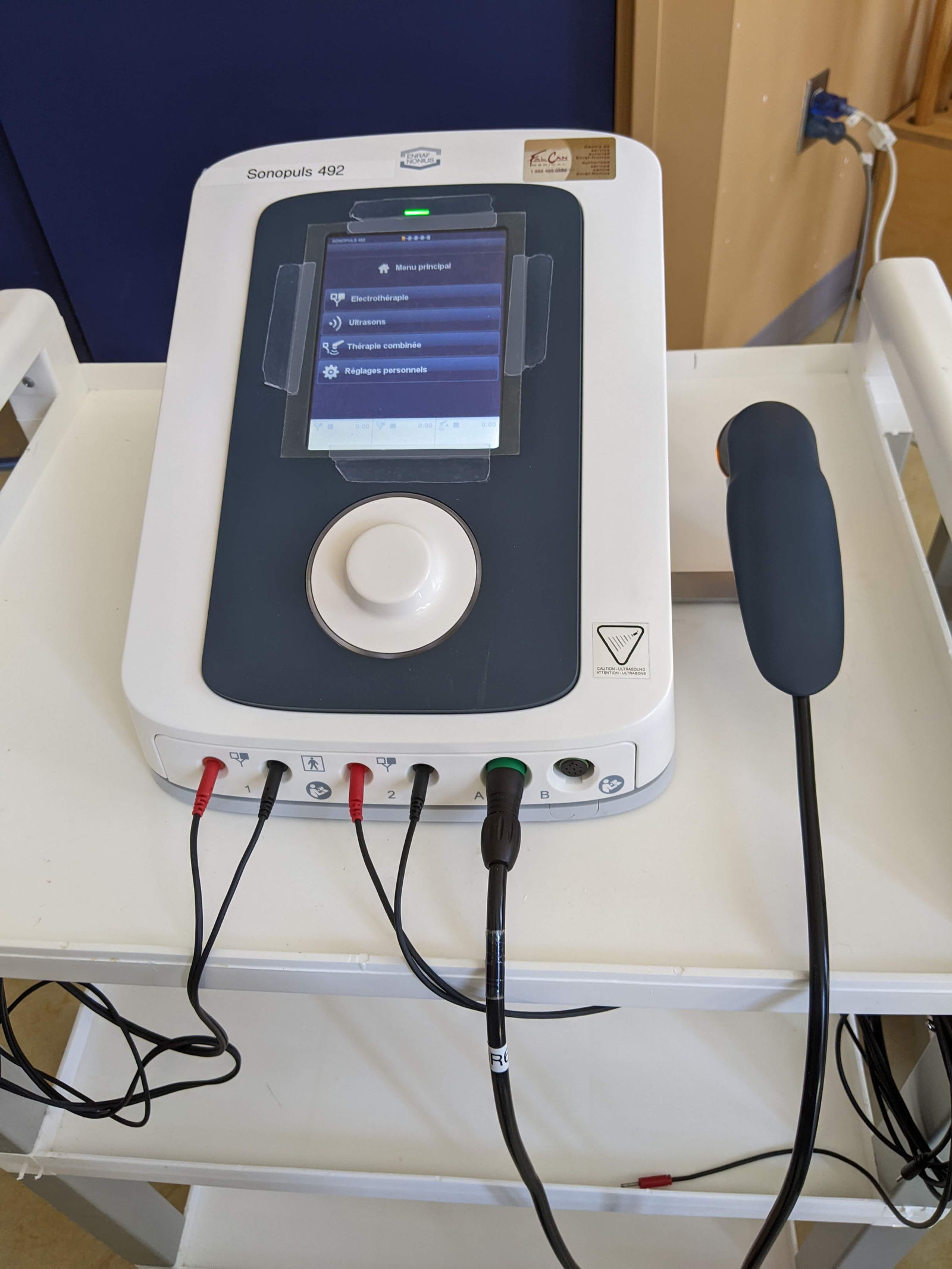 Equipo de terapia combinada con cabezal de ultrasonido y electrodo aplicado en la espalda alta