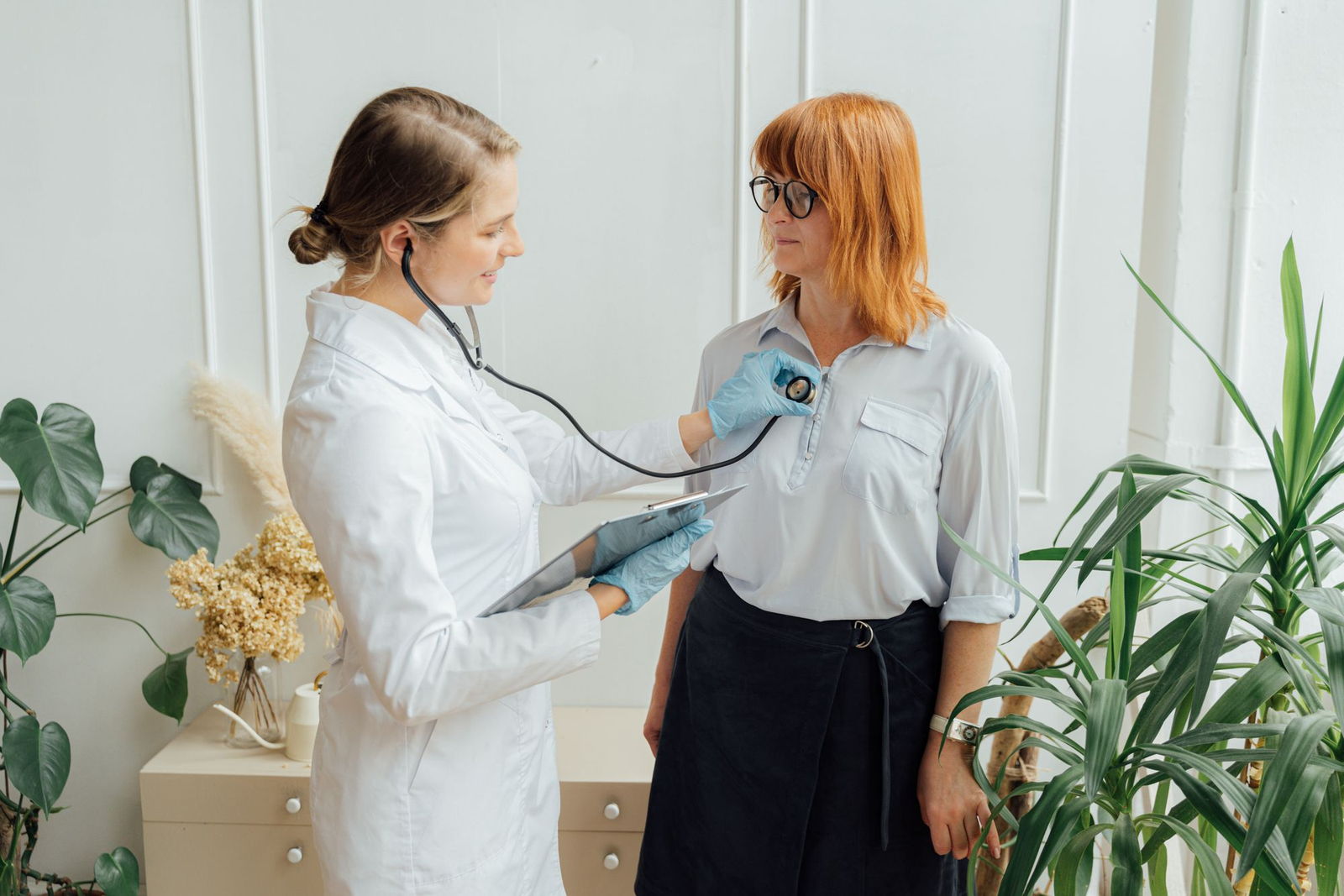 Fisioterapeuta guiando a un paciente adulto en el uso de un dispositivo de entrenamiento respiratorio